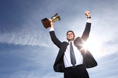 Businessman celebrating with trophy in hand